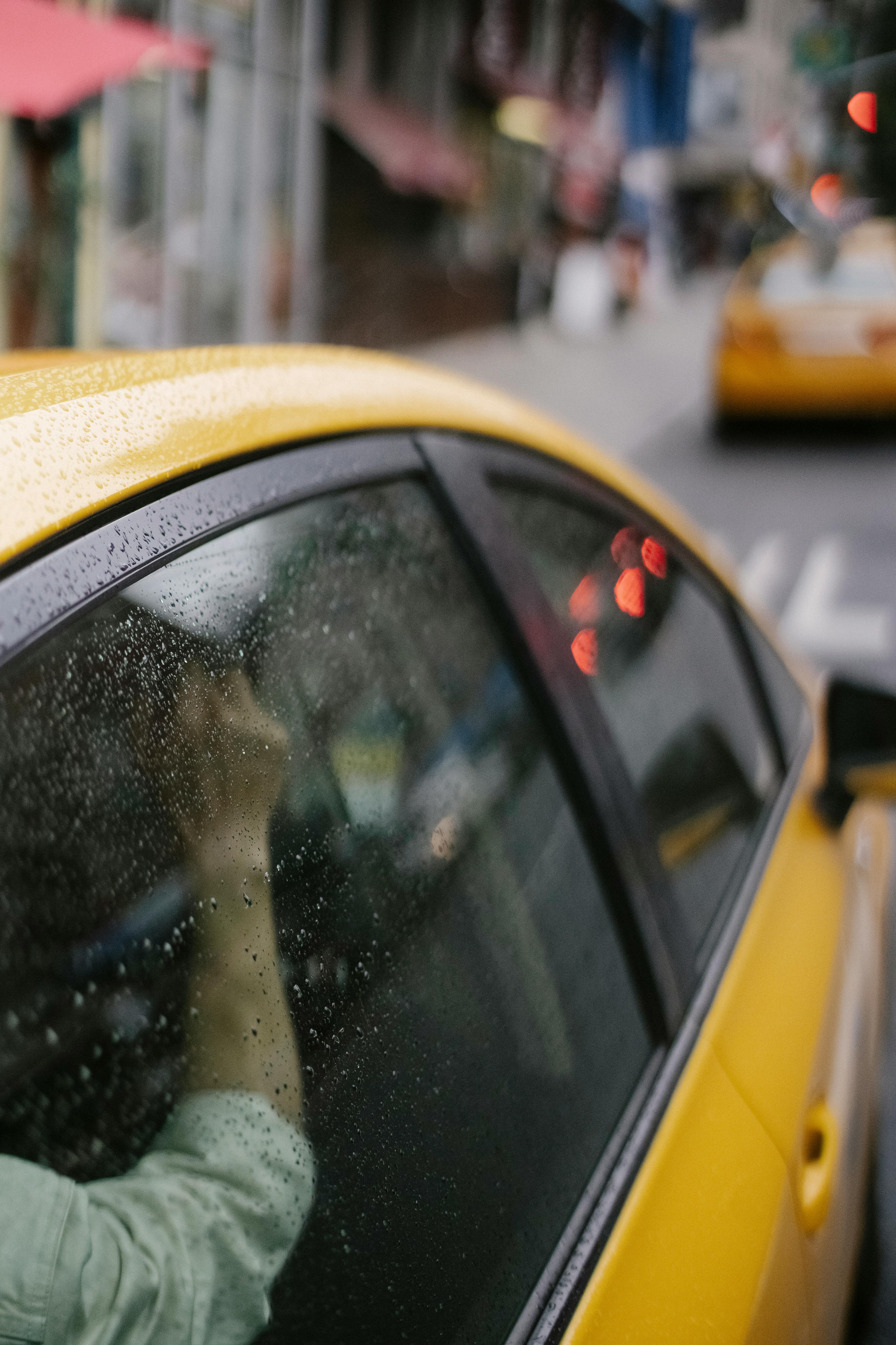 yellow cab with client driving along road in city downtown