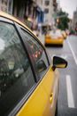 Yellow taxi cars riding along busy road in megapolis