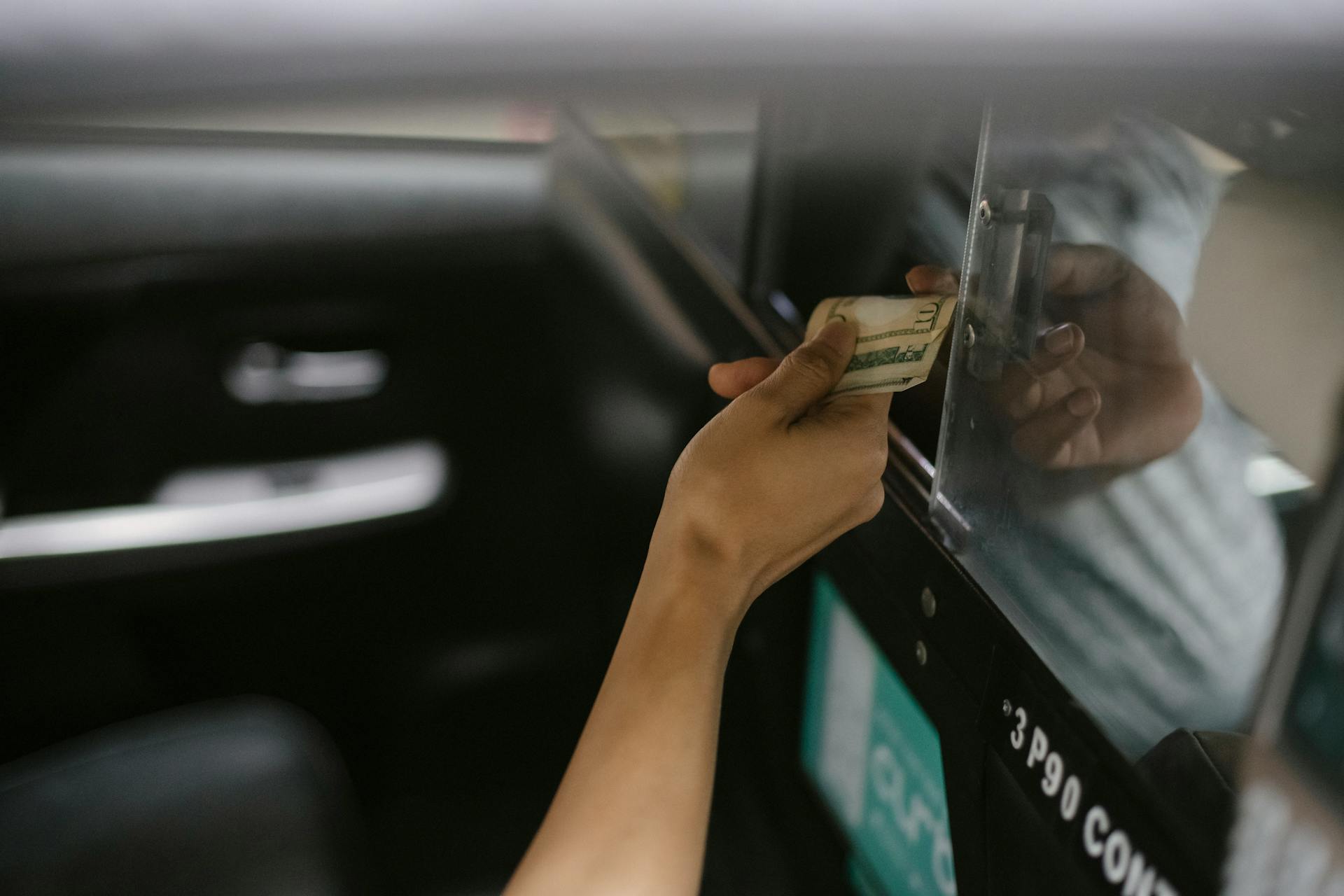 Interior of modern taxi car while passenger paying for ride