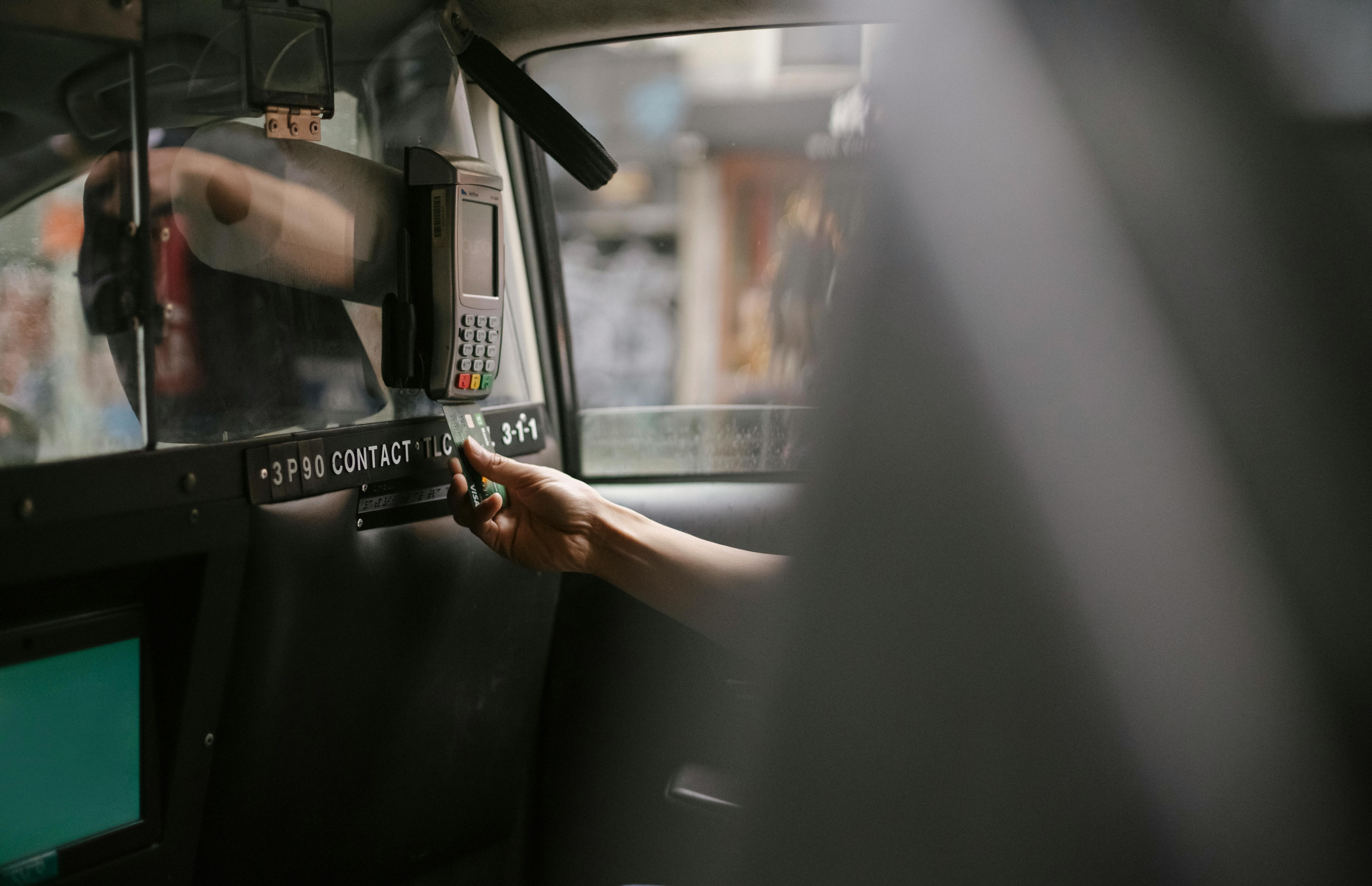 passenger using credit card for paying taxi ride