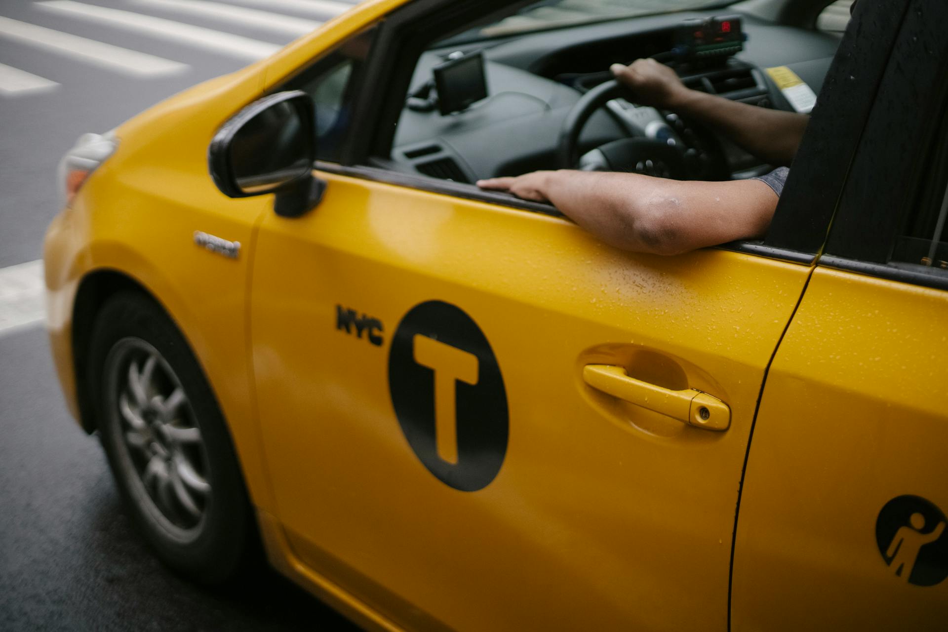 Taxi driver in car riding on road