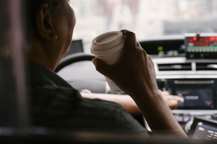 Faceless Driver Drinking Coffee While Driving Car