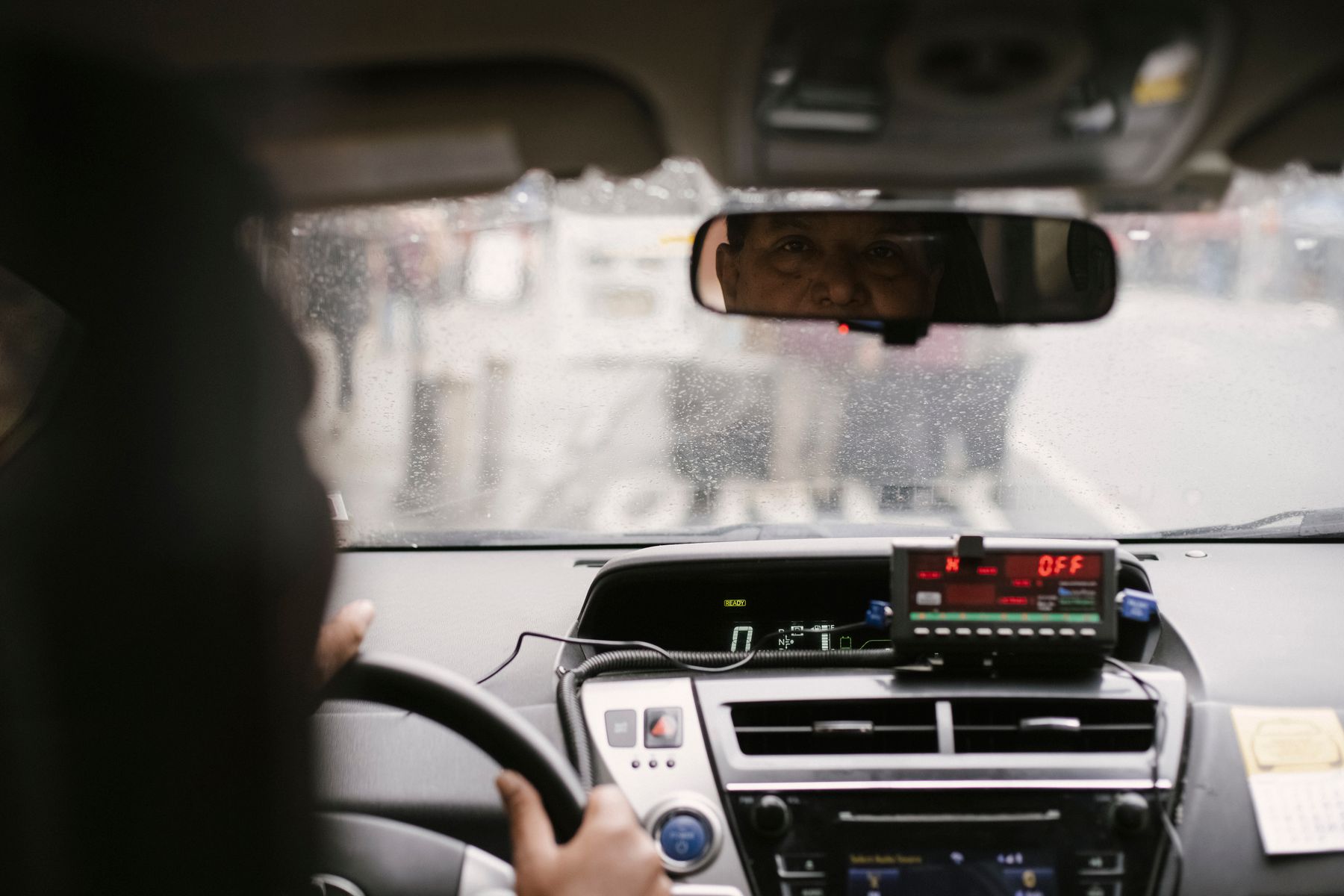 Driver checking mirrors inside a vehicle during city driving