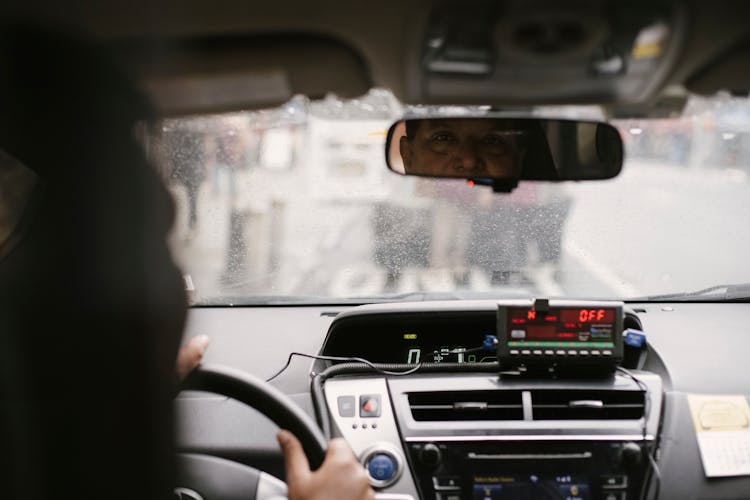 Man Driving Car While Looking At Mirror