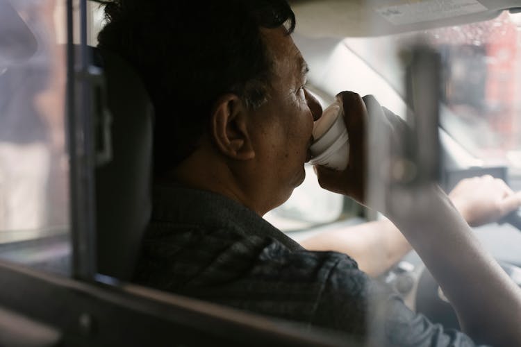 Ethnic Taxi Driver With Cup Of Coffee