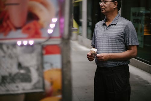 Pria Etnis Dengan Uang Di Dekat Kafe Makanan Jalanan