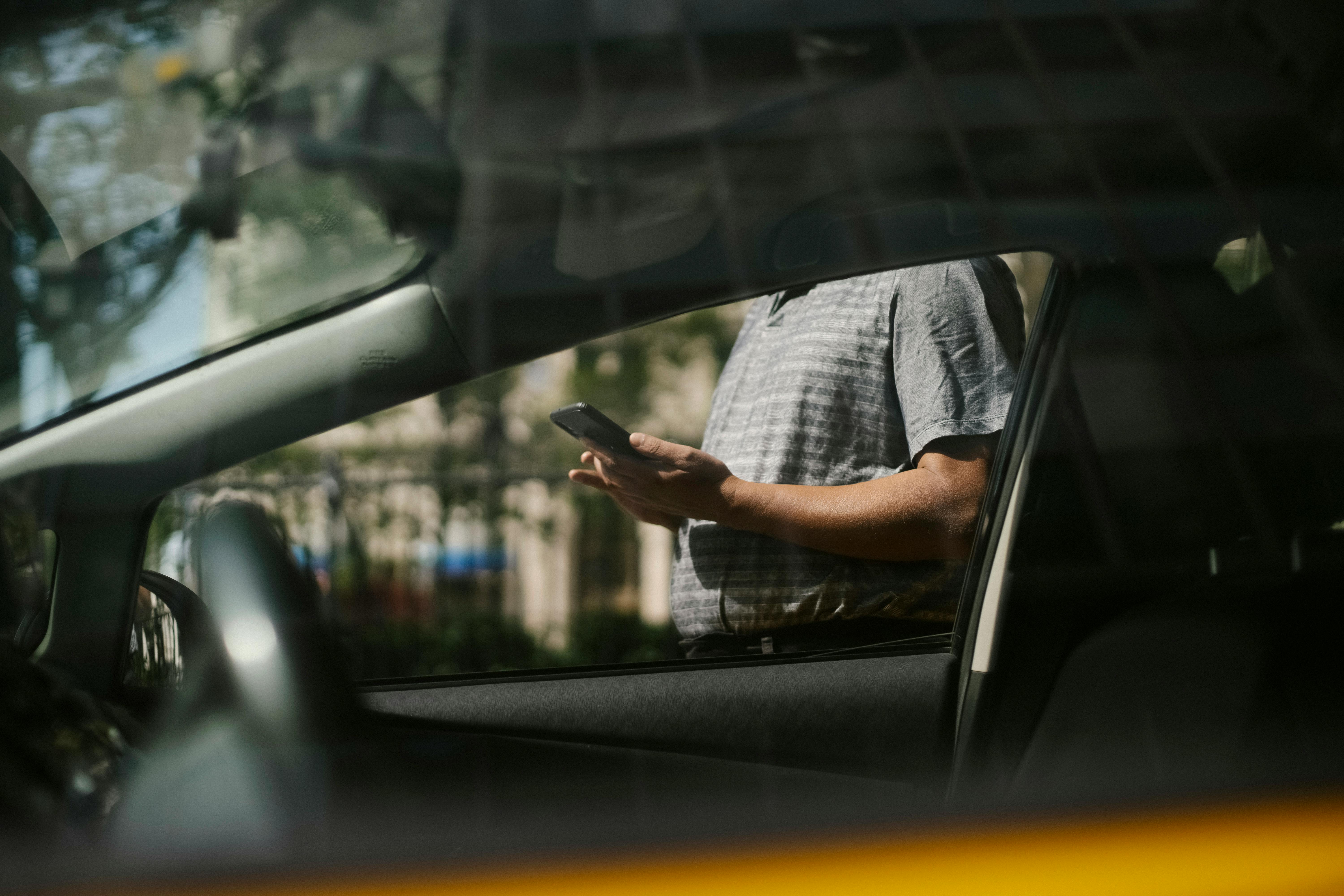 man using smartphone near taxi car