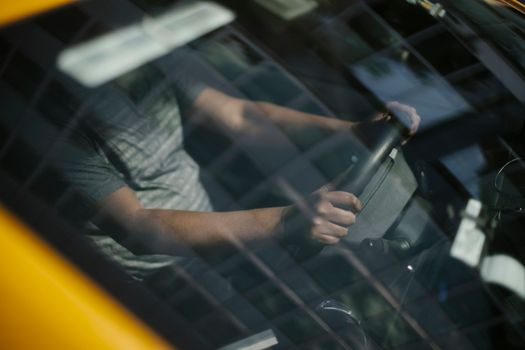 在城市工作时，少数族裔男性司机透过驾驶室的挡风玻璃