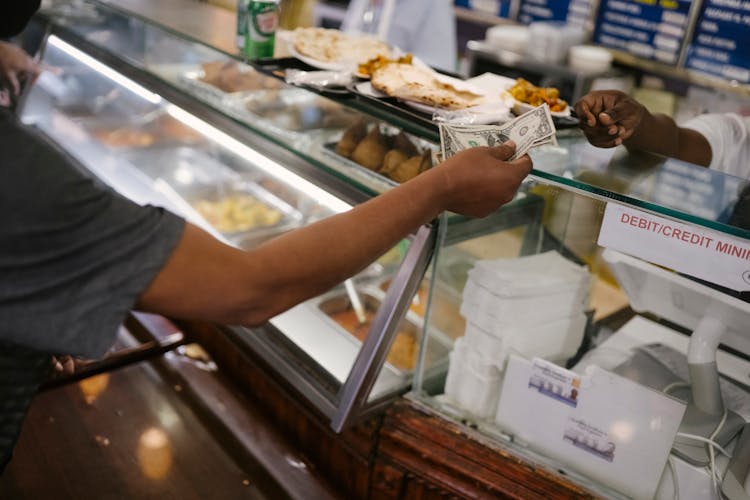 Person Paying Money For Food In Cafe