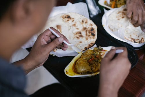 Person eating pita and meat for lunch