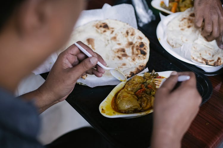 Person Eating Pita And Meat For Lunch