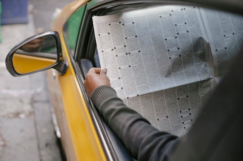Free Person reading newspaper sitting in car Stock Photo