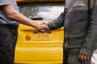 Side view of crop ethnic anonymous males shaking hands while meeting each other on street