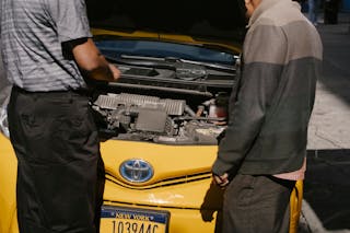 Men fixing problem in motor of car