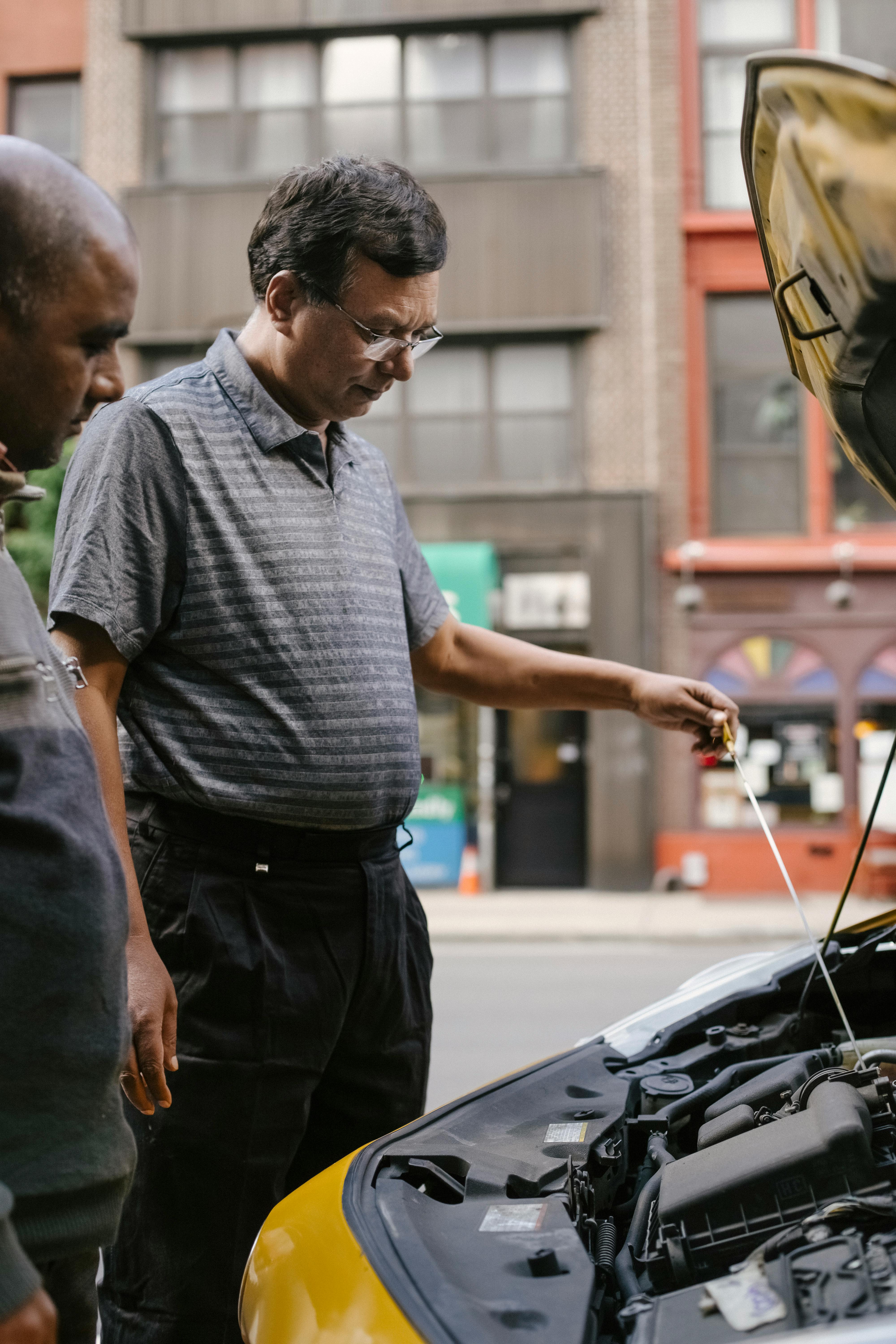 ethnic men inspecting car with opened hood