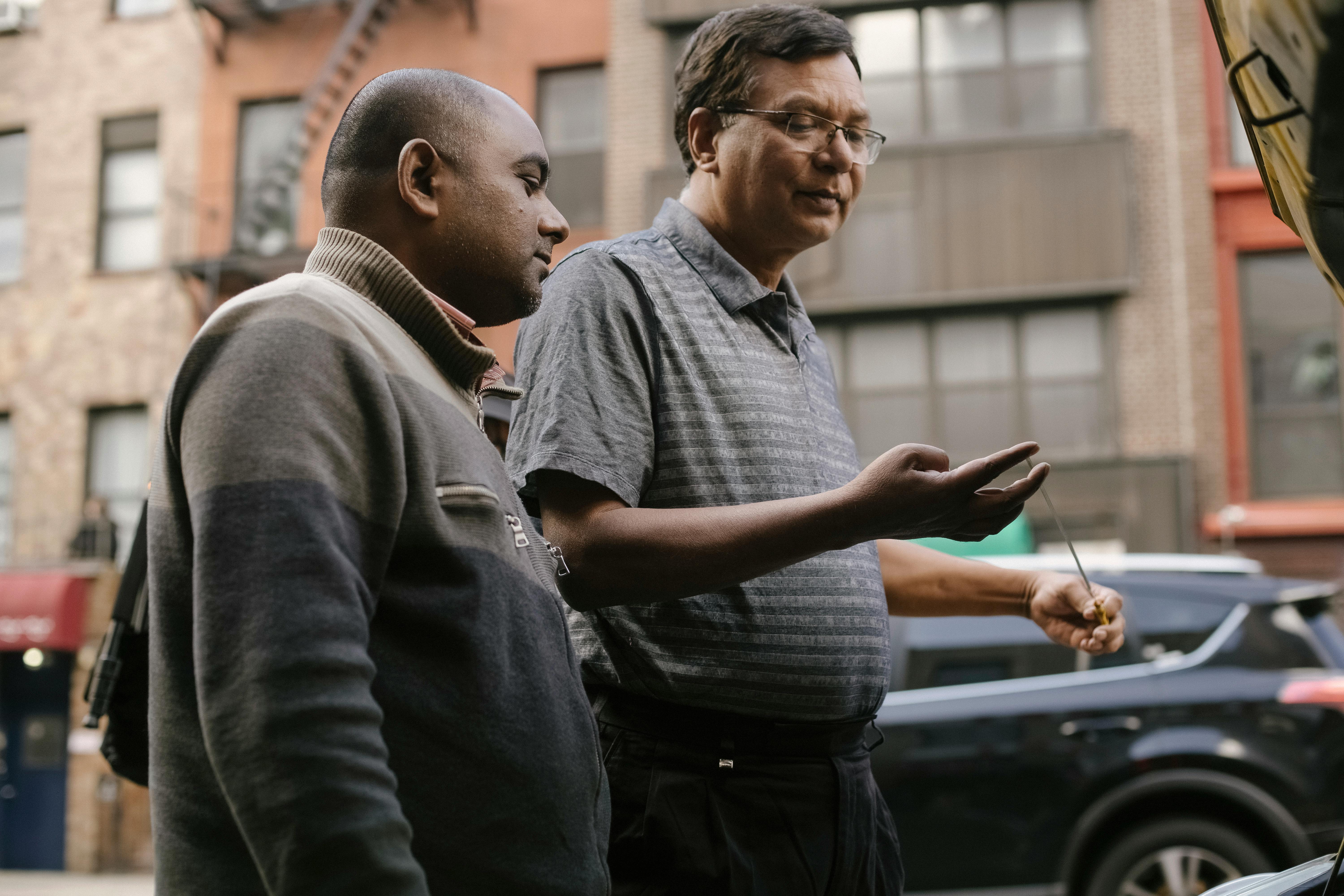 multiracial male friends talking on city street