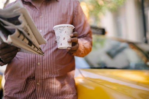 Taxista étnico Com Café E Jornal Para Viagem