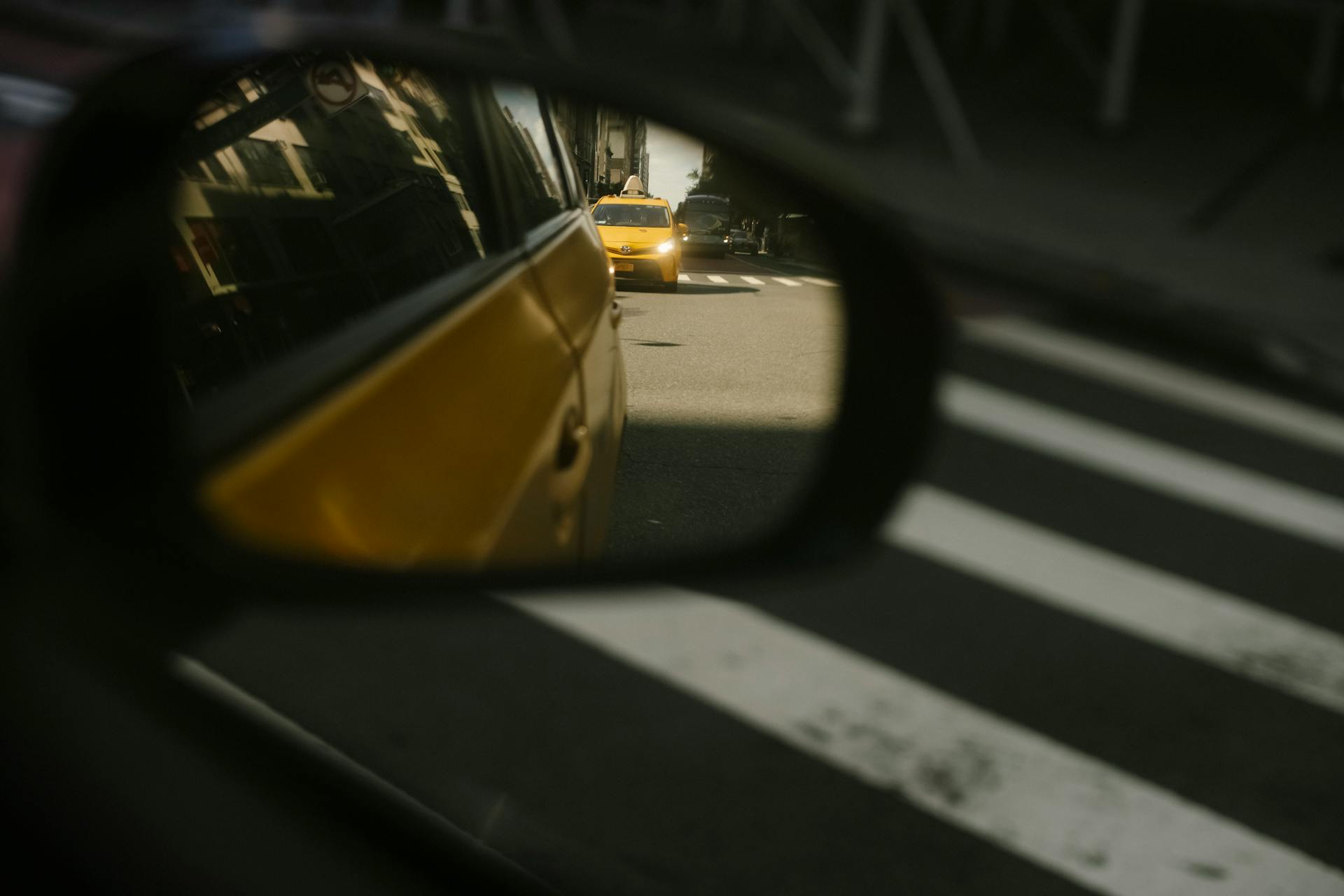 Modern taxi cars driving on road with crosswalk