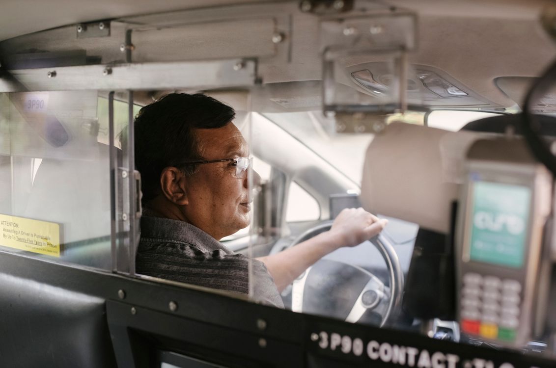 Chauffeur taxi professionnel - garanties assurance indispensables Chauffeur de taxi professionnel au volant, concentré sur la route en milieu urbain