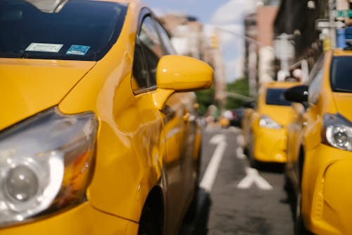 Красочные современные автомобили такси на городской дороге