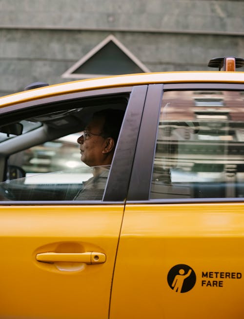 Attentive Asian male taxi driver in modern car