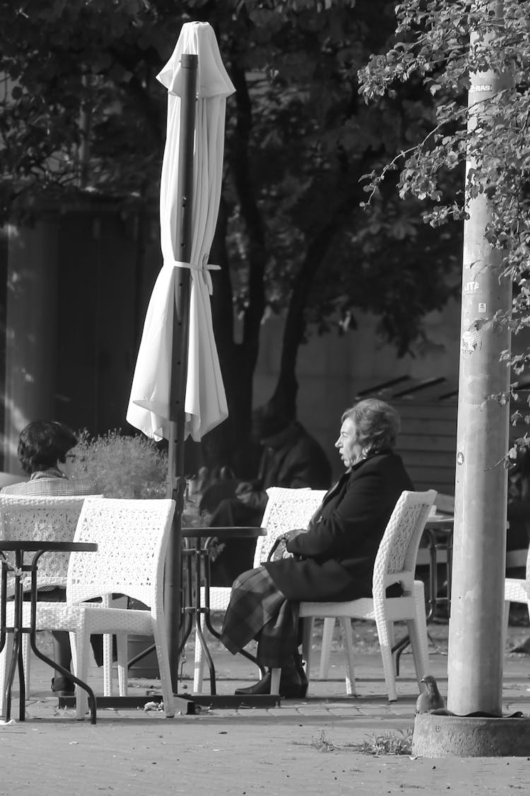 Elderly Woman Sitting On White Chair 