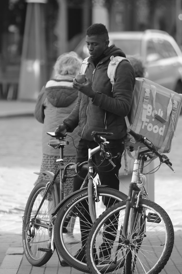 Man With A Delivery Bag Eating An Apple