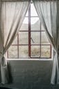 Red Framed Glass Window with White Curtains