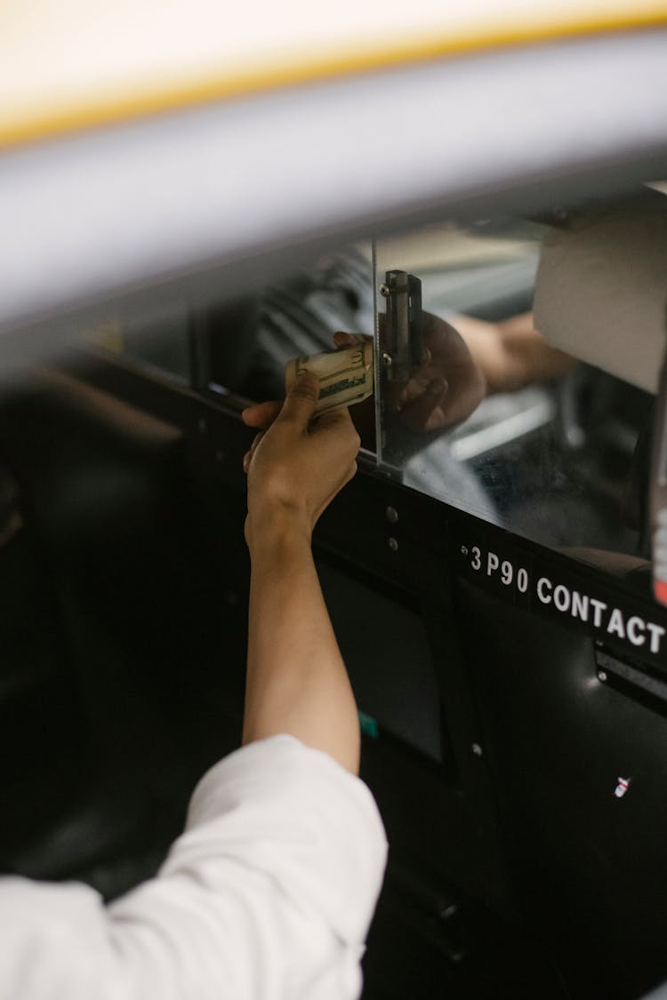 Crop Person Paying For Taxi In Car