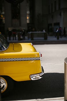 Classic yellow taxi cab parked on a city street, showcasing retro automotive design.