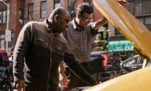 Focused multiracial male friends in casual clothes standing near opened hood of vehicle and looking at details