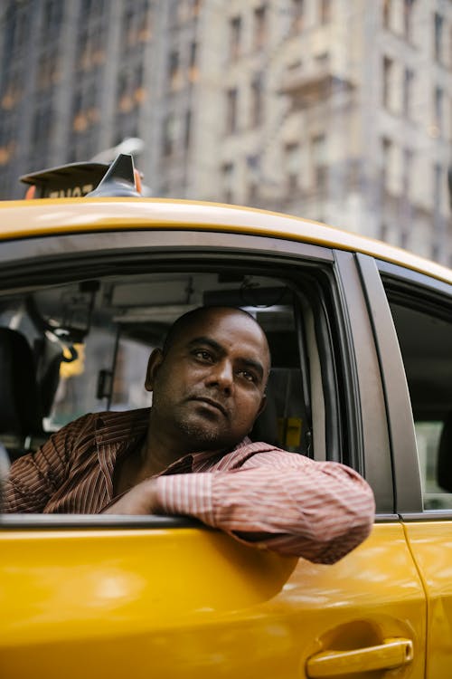 Free Man in Black and White Striped Shirt Sitting Inside Yellow Car Stock Photo