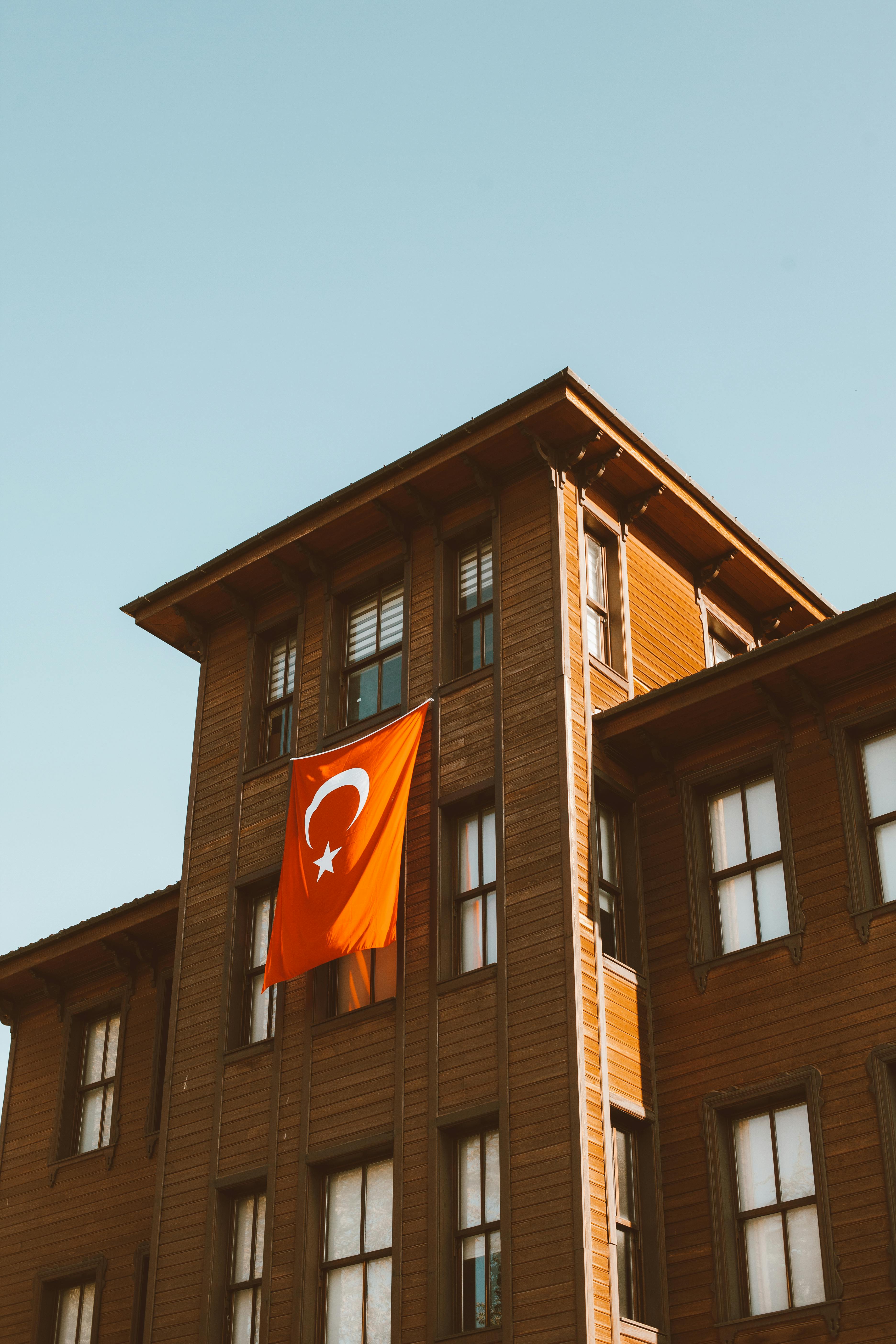 low angle shot of a brown building with turkish flag