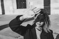 Woman in Long Sleeve Shirt Covering Face with Hand
