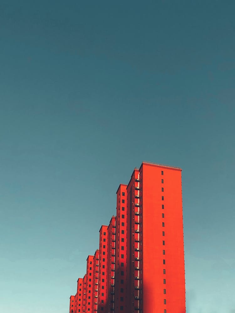 Multiple Uniform Red Buildings Under Blue Sky