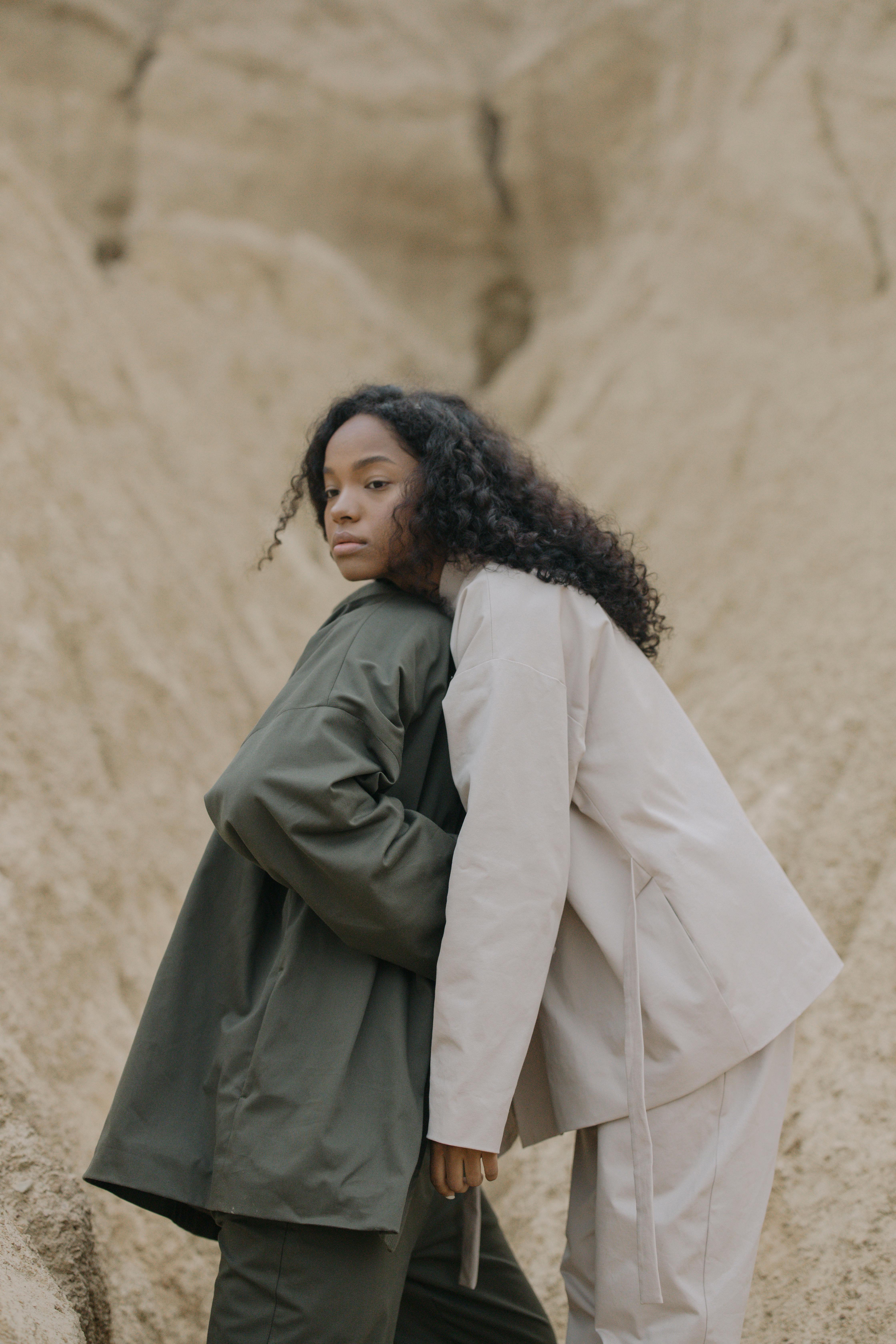 woman in white jacket leaning on person in gray suit