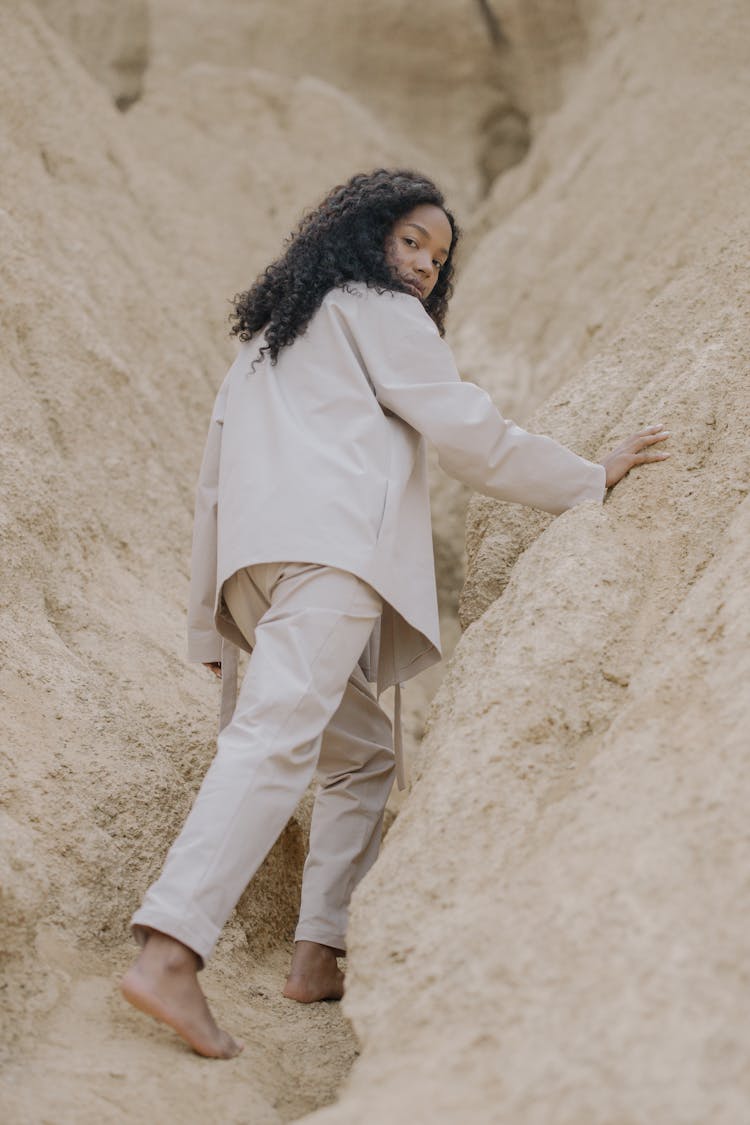Woman In White Pajama Walking Up On Sand