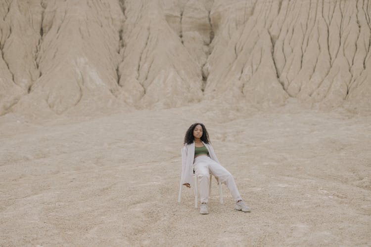 Woman In White Long Sleeve Shirt And White Pants Sitting On Chair