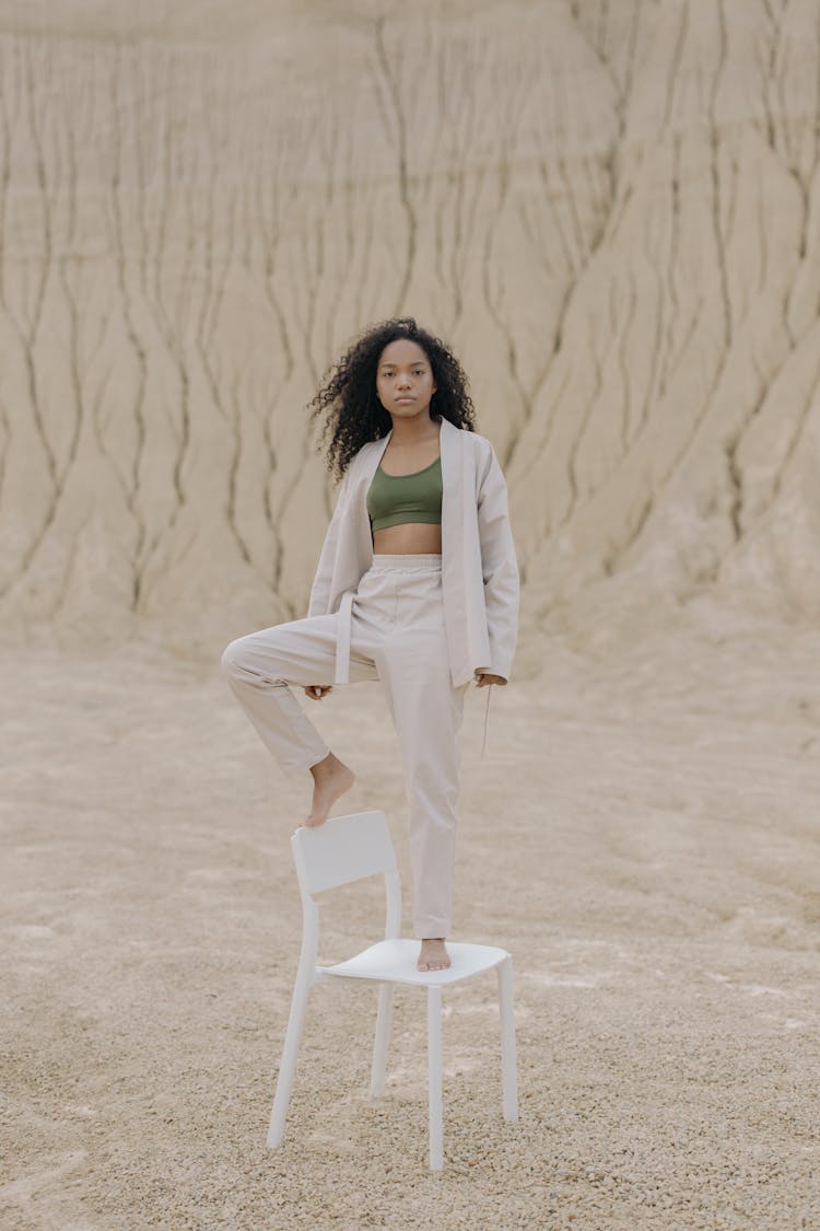 Woman Standing On Top Of White Chair