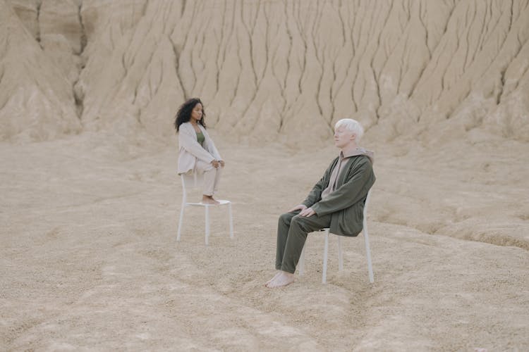 Man And Woman Sitting On White Chair