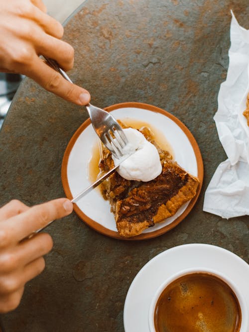 Free Hands with Fork and Knife Slicing White Cream on Pie Stock Photo