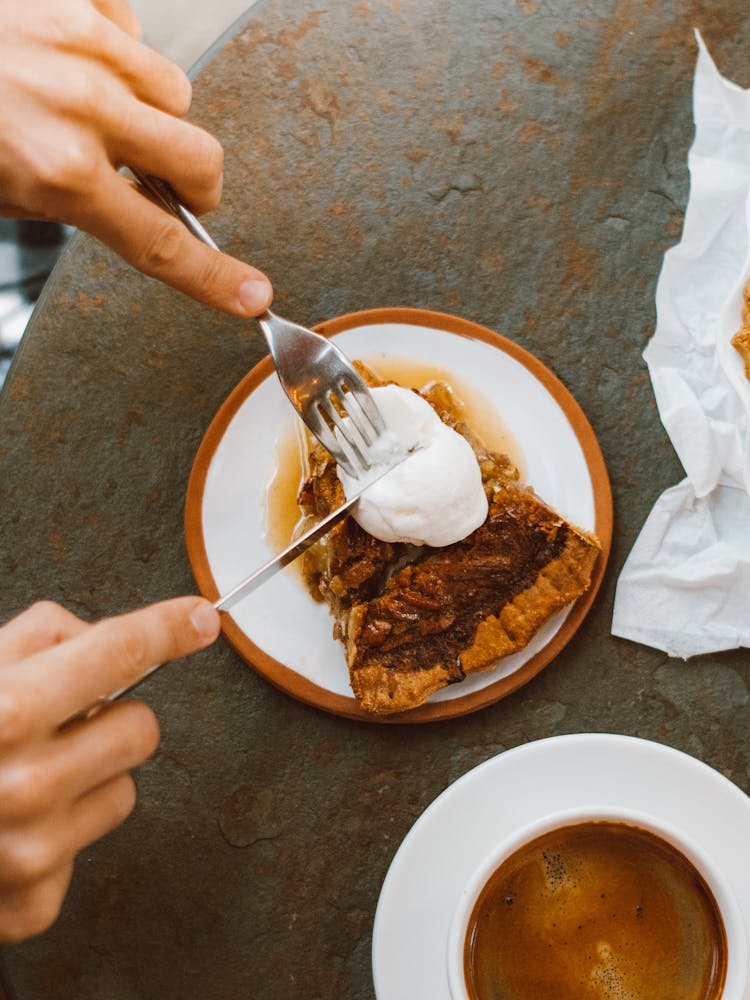 Hands With Fork And Knife Slicing White Cream On Pie