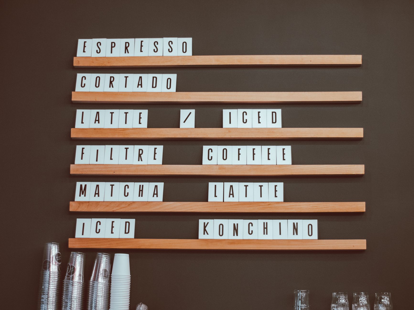 Stylish coffee shop menu board with coffee options like espresso and latte in a cafe setting.