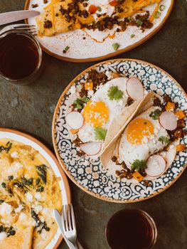 Top view of brunch spread featuring tacos, omelets, and refreshing drinks, perfect for food photography.