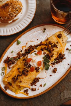 Spicy chorizo omelette garnished with fresh herbs and sour cream on a rustic table setting.