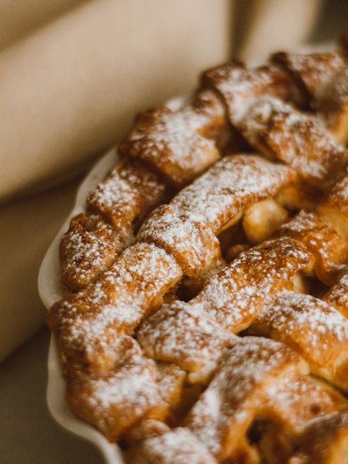 Free Close-up of a freshly baked apple pie with a lattice crust, sprinkled with powdered sugar. Stock Photo
