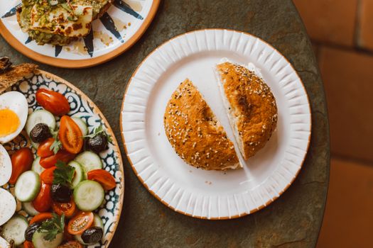 A delicious top view of a healthy breakfast featuring a bagel and fresh vegetable salad.