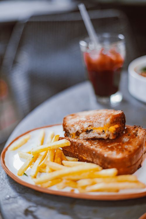 Free Tantalizing grilled cheese sandwich with crispy fries on a rustic plate. Perfect for comfort food lovers. Stock Photo