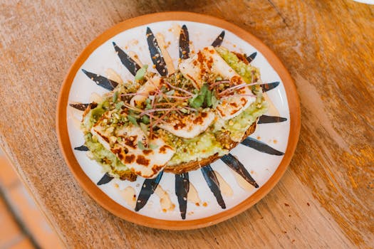 Close-up of avocado toast with grilled halloumi on a decorative plate, perfect for food blogs.