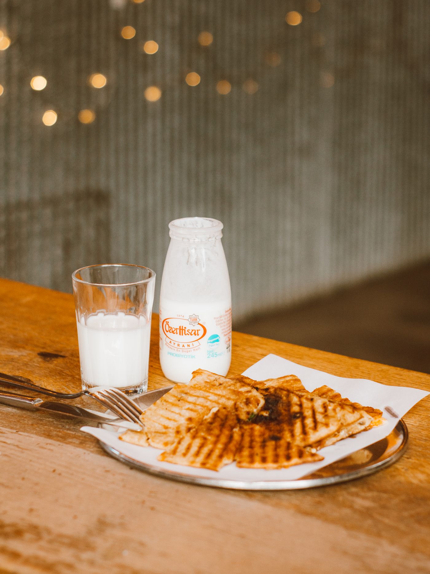 Golden waffles served beside a glass on a rustic breakfast table